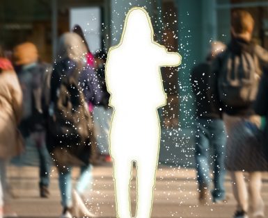 People walking on a city street. One of them is missing, with only a white cut-out of her shape left behind.