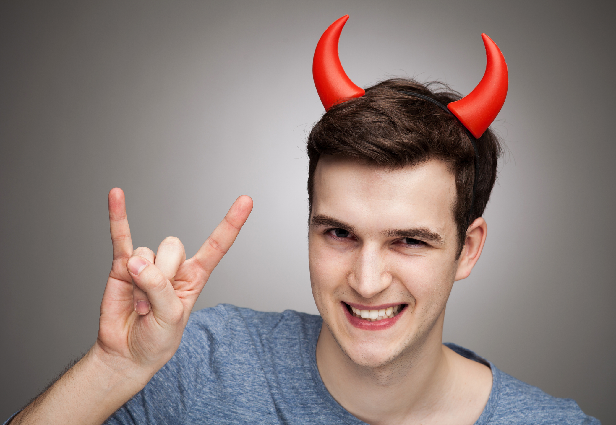 Man wearing devil horns