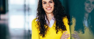 Young woman with arms crossed smiling to the camera