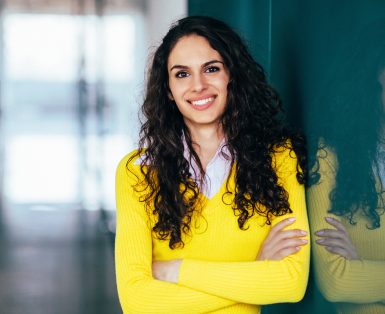 Young woman with arms crossed smiling to the camera