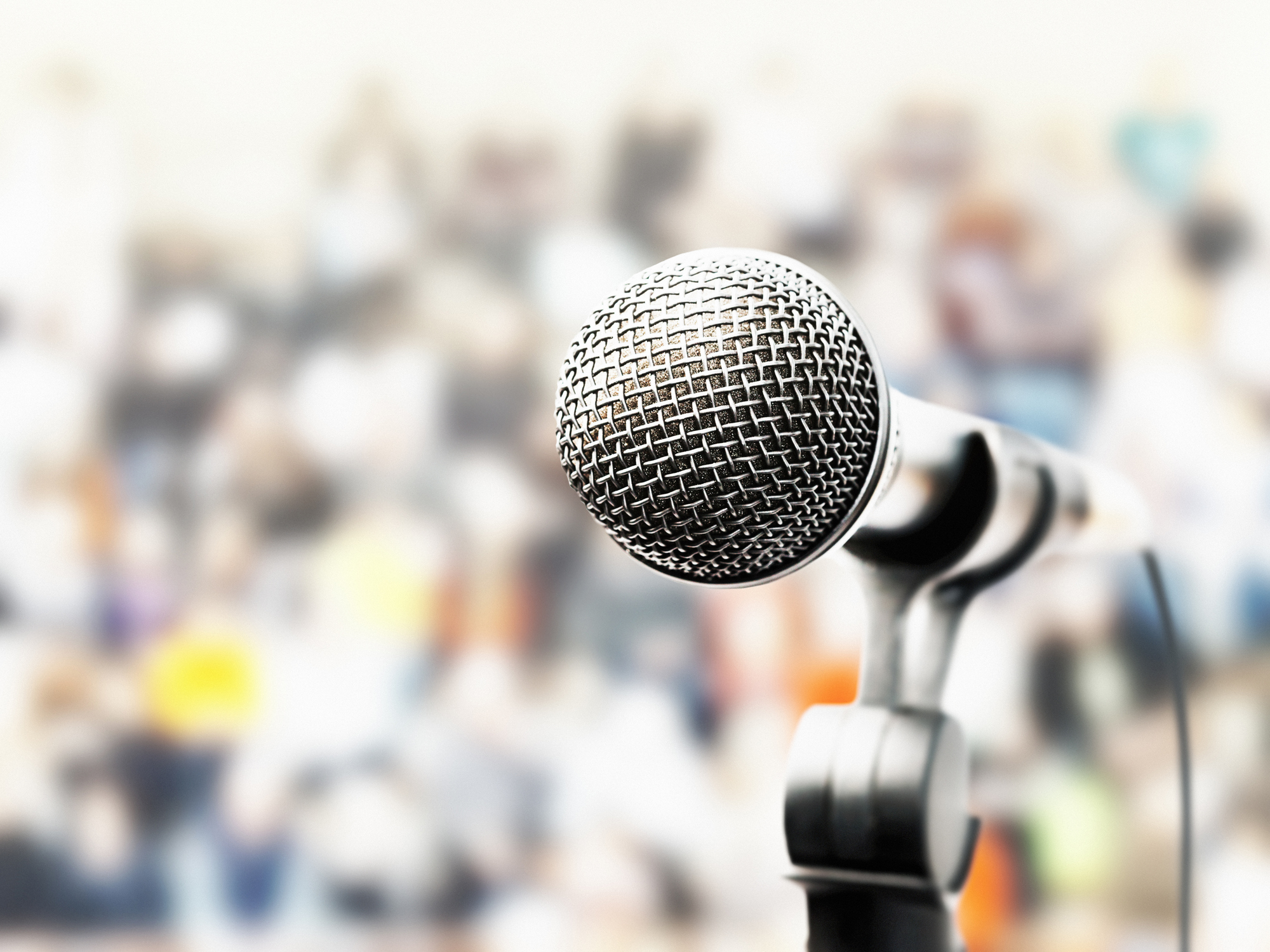 Dynamic microphone on stage as a large crowd await a singer or public speaker.