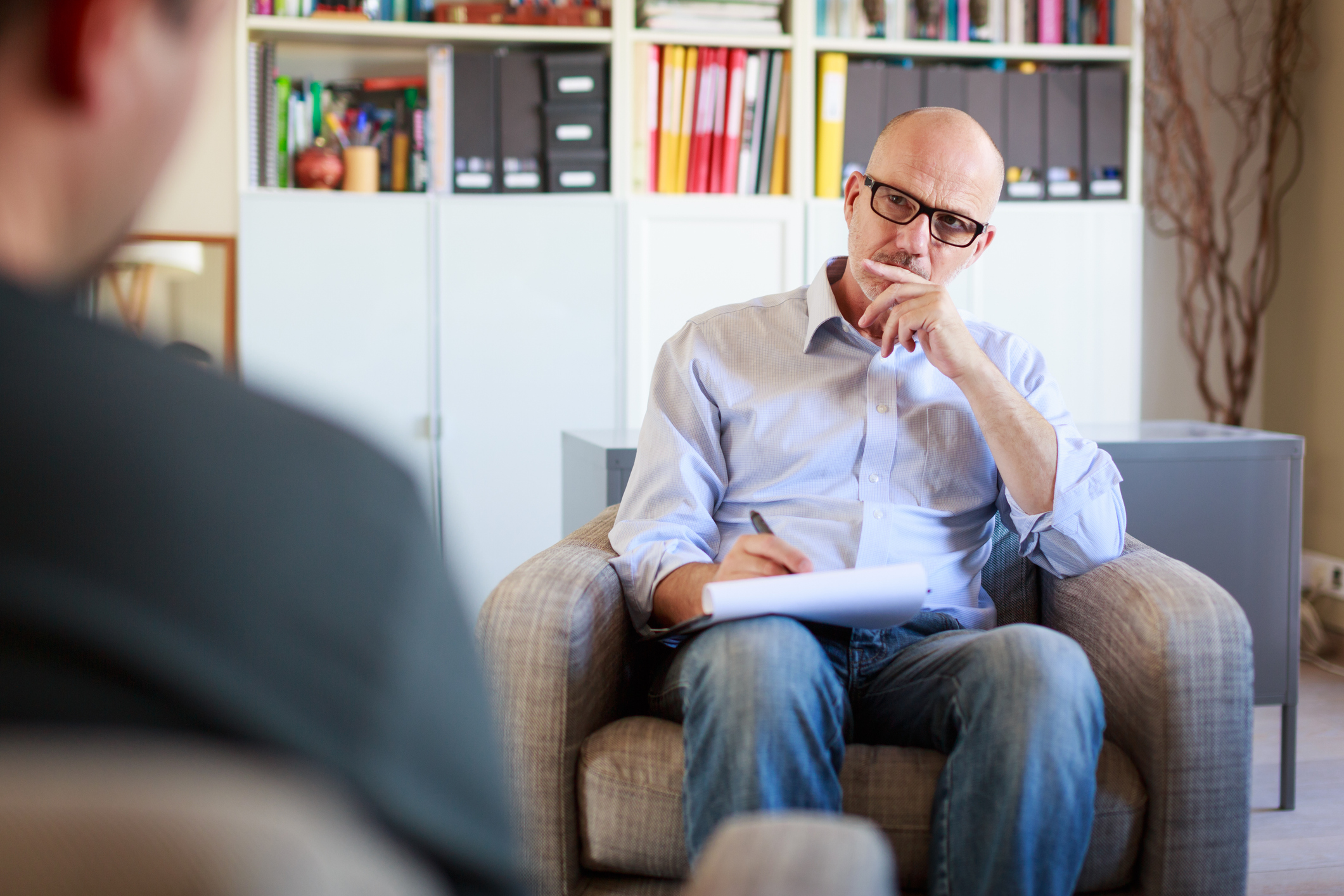 A man attentively listening to another person seated opposite him