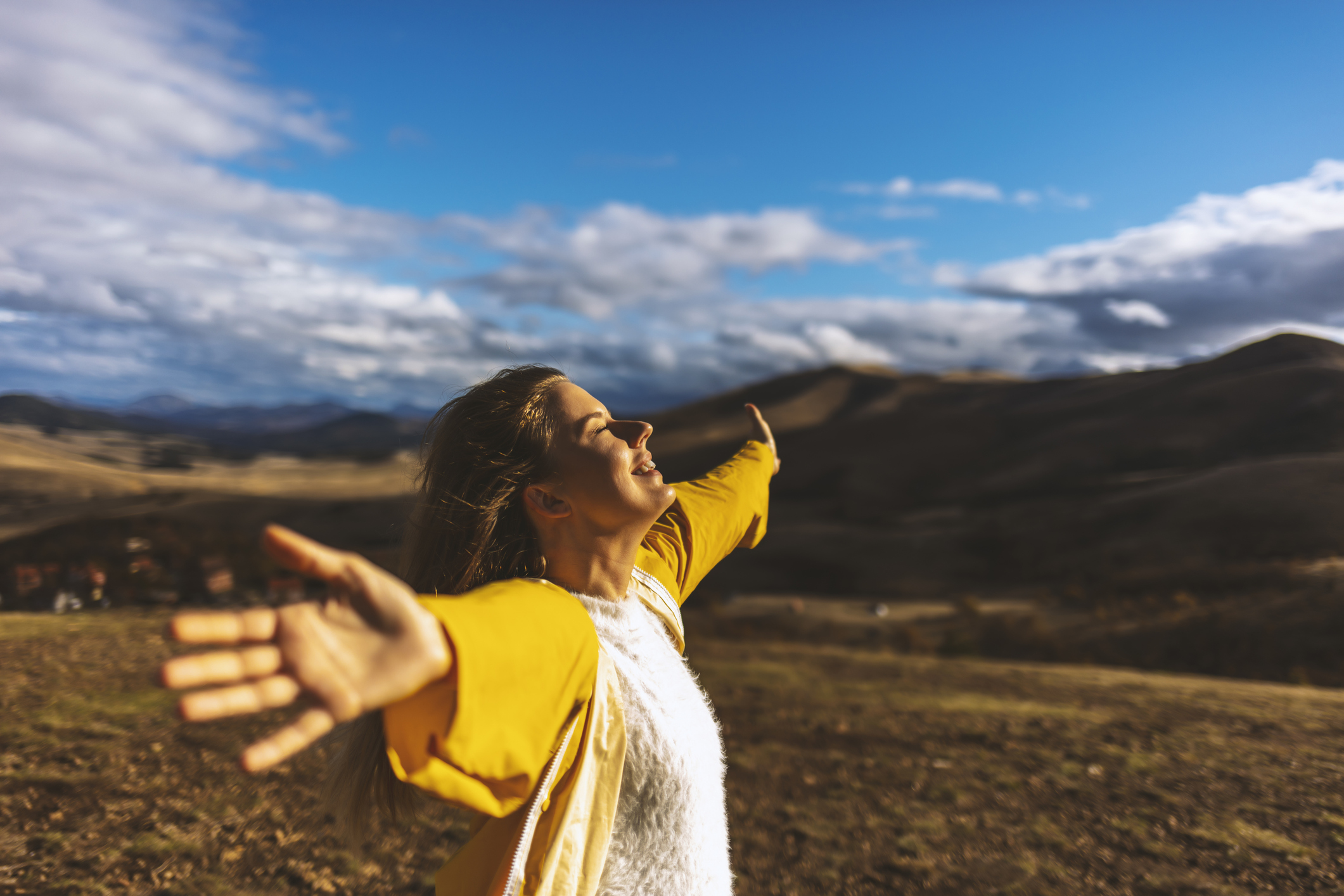 Happy woman on the sunset in nature in autumn with open hands. Young woman with eyes closed. Stress free concept.