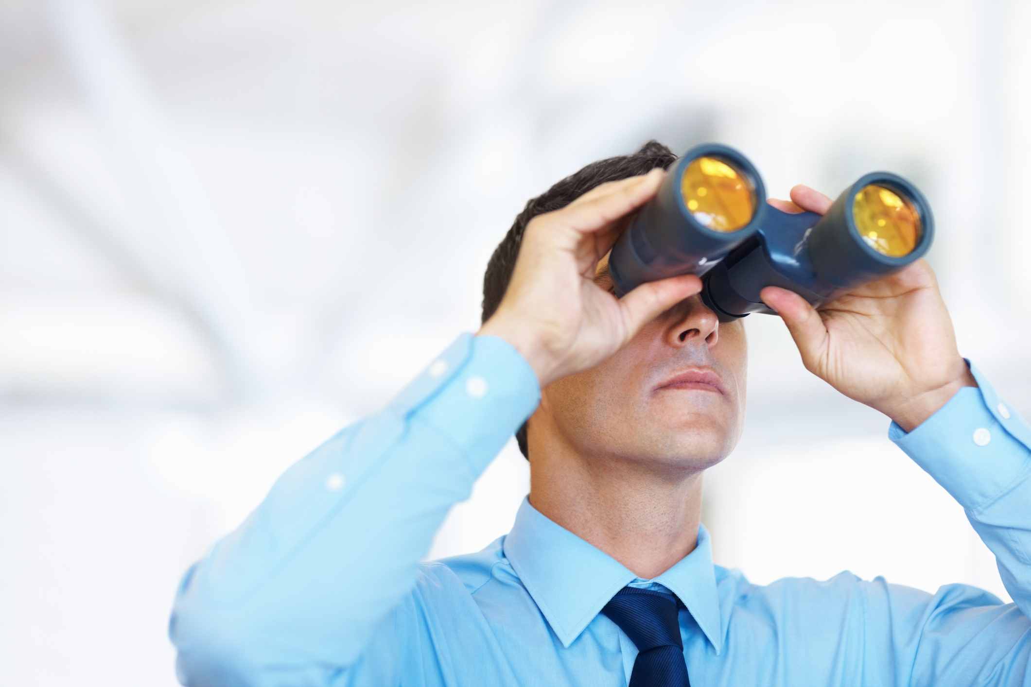 Portrait of handsome business man looking through binoculars