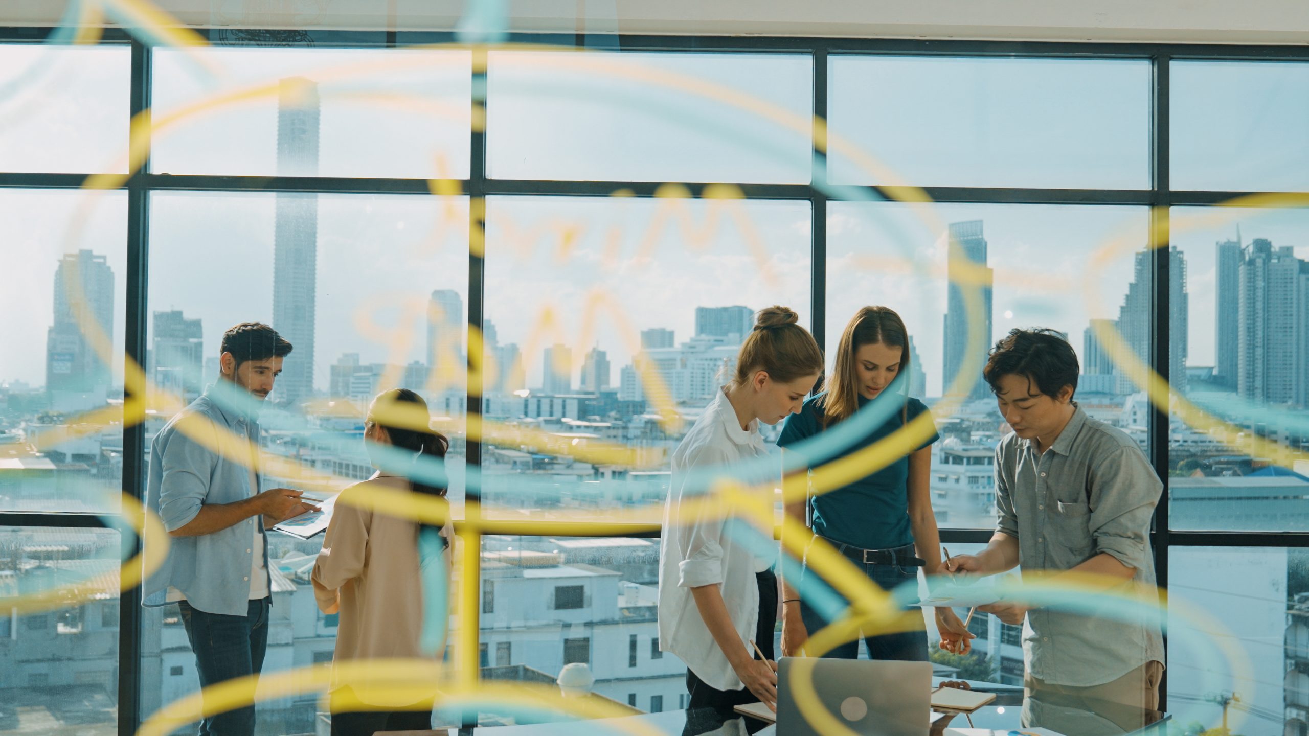 Diverse business people brainstorm with idea written on glass wall. Tracery