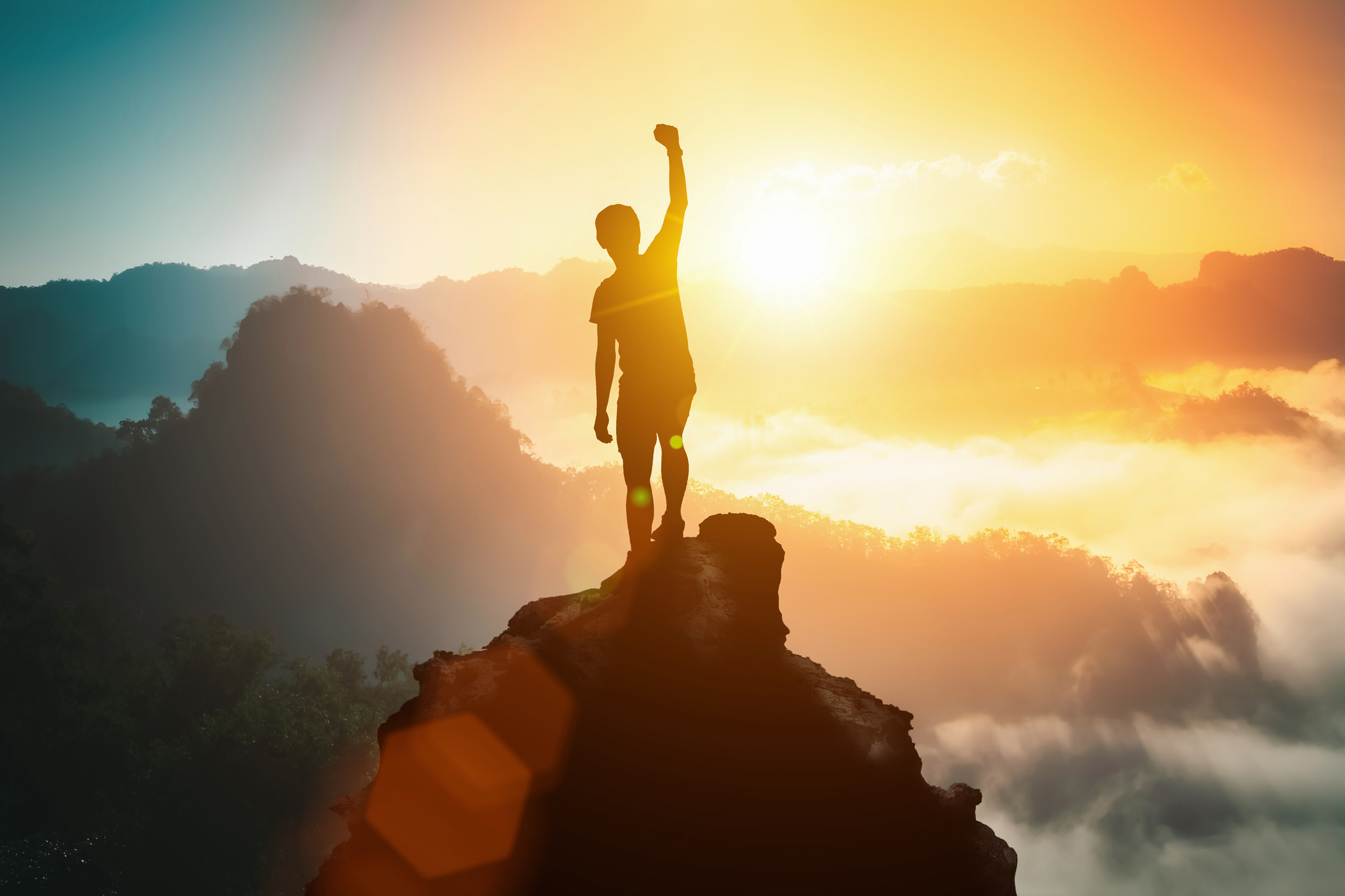 Silhouette of positive man celebrating on mountain top, with arms raised up, silhouette of man standing on the hill, Business, success,victory,leadership,achievement concept. Freedom travel adventure.